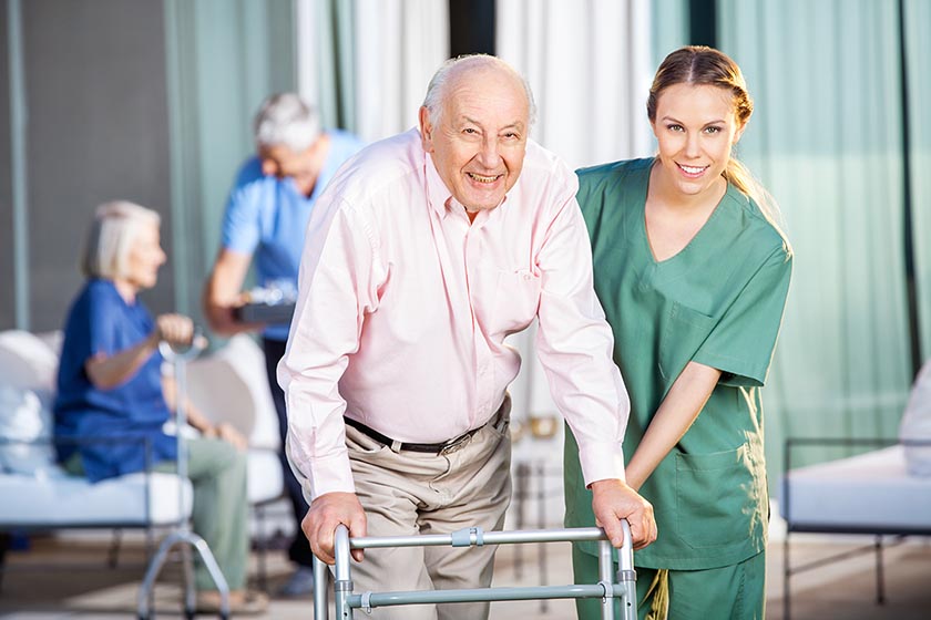 Carer with older person in aged care facility